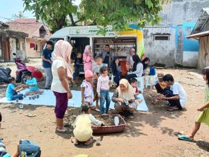 Anak- anak bersama orang tuanya sedang bermain dan membaca di Seketariat TBM Koleang Muncang